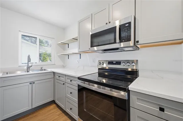 a kitchen with a sink and steel appliances