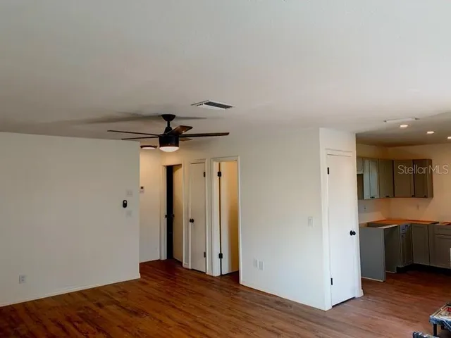 a view of a hallway with wooden floor and a sink