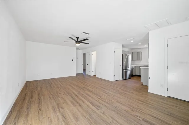 a view of a livingroom with a ceiling fan & wooden floor