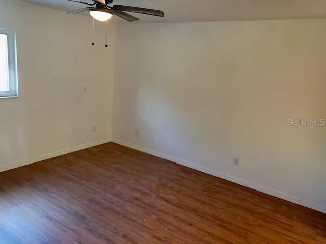 a view of a room with wooden floor and fan