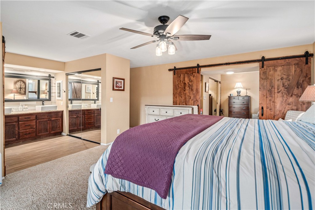 2862 Calmgarden Road Acton, CA 93510 - Photo 21 of 69 a spacious bedroom with a large bed and a chandelier