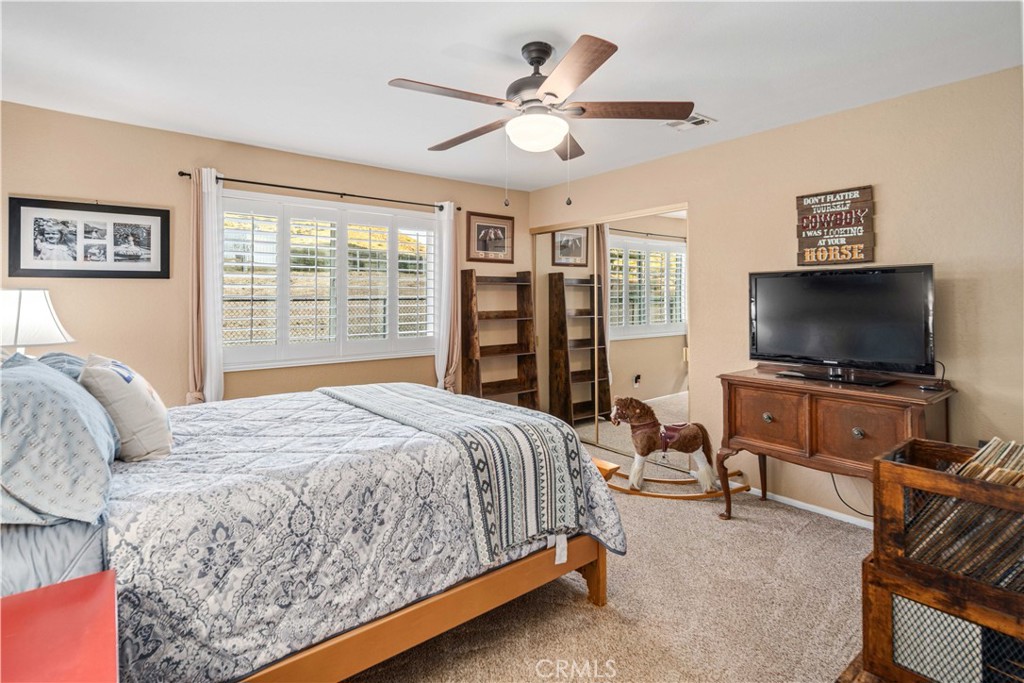 2862 Calmgarden Road Acton, CA 93510 - Photo 28 of 69 a bedroom with a large bed a flat screen tv and a window