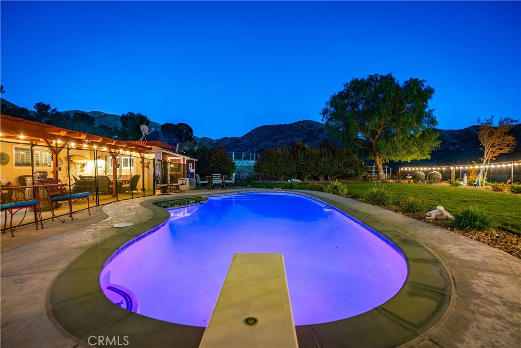 2862 Calmgarden Road Acton, CA 93510 - Photo 43 of 69 a view of a swimming pool with lawn chairs under an umbrella