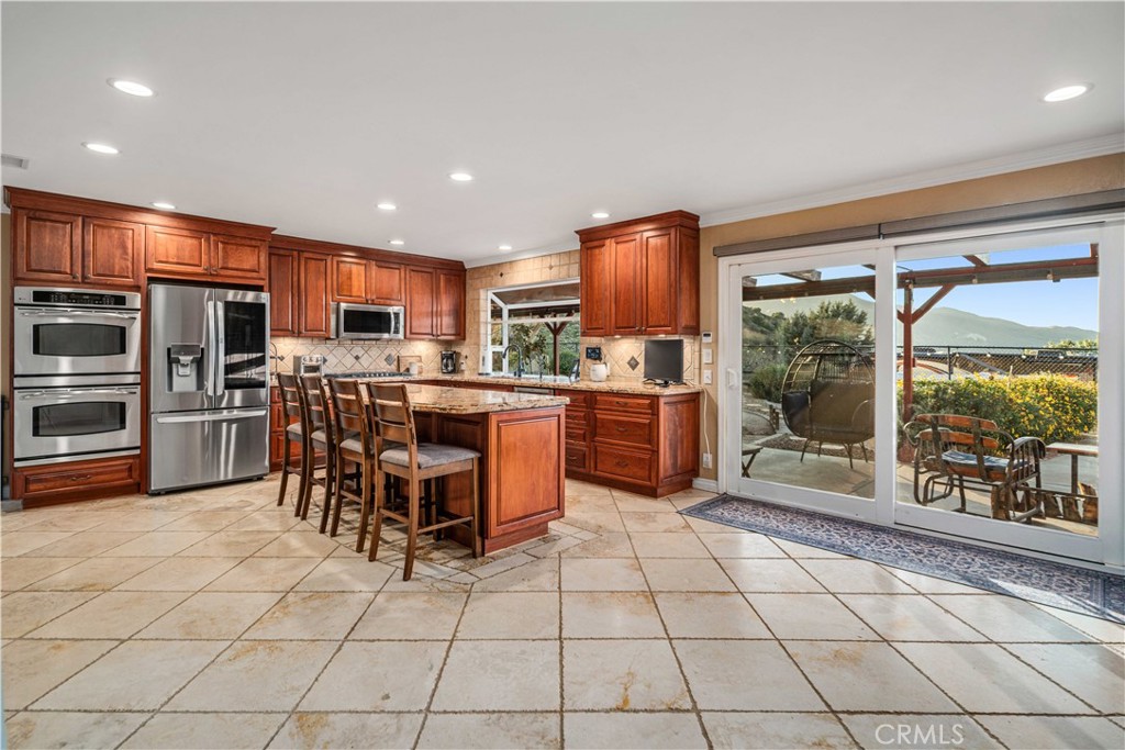 2862 Calmgarden Road Acton, CA 93510 - Photo 8 of 69 a kitchen with stainless steel appliances kitchen island granite countertop a refrigerator and a stove top oven