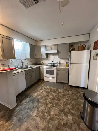 a kitchen with a sink a refrigerator and cabinets