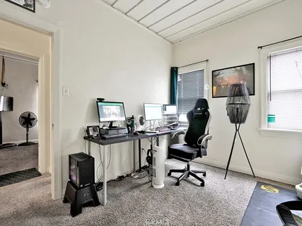 a view of a workspace with furniture and a window