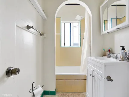 a bathroom with a sink a mirror a vanity and a shower