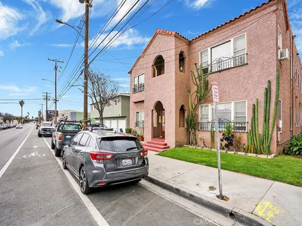 a car parked in front of a brick house with a small yard
