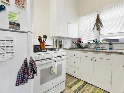 a kitchen with white cabinets and appliances