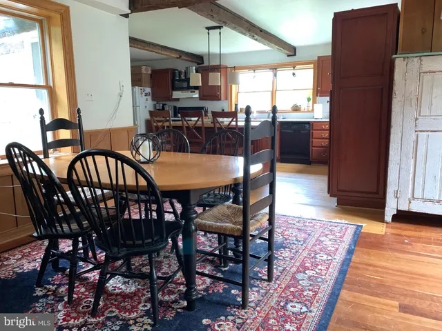 a dining room with furniture window and wooden floor