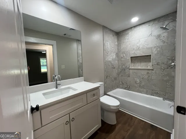 a bathroom with a sink and mirror with toilet
