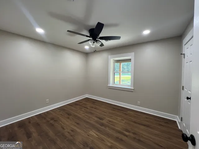 a view of a big room with wooden floor and a ceiling fan