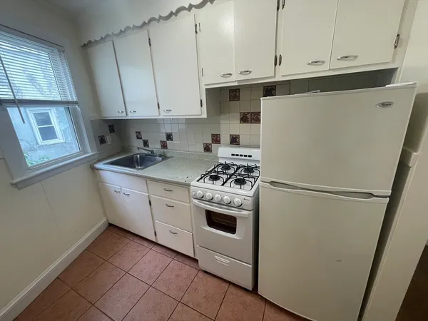 a kitchen with white cabinets and white appliances
