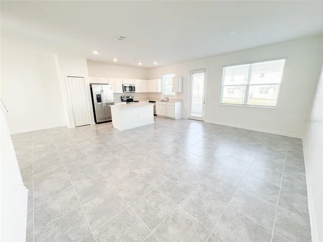 a view of a kitchen with refrigerator and window