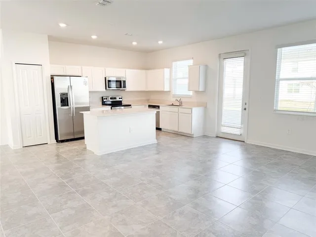 a large kitchen with cabinets stainless steel appliances and a counter space