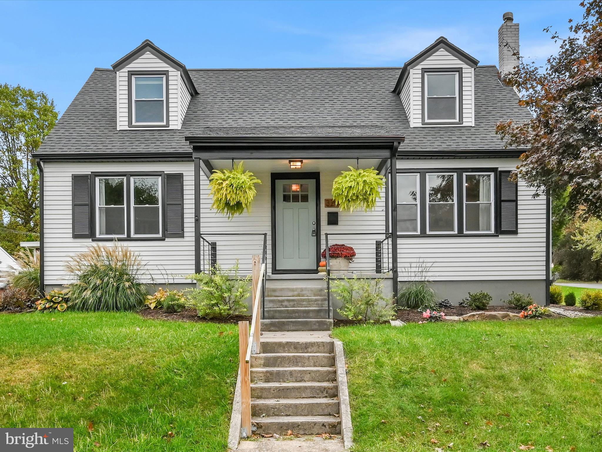 a front view of a house with a yard and garden