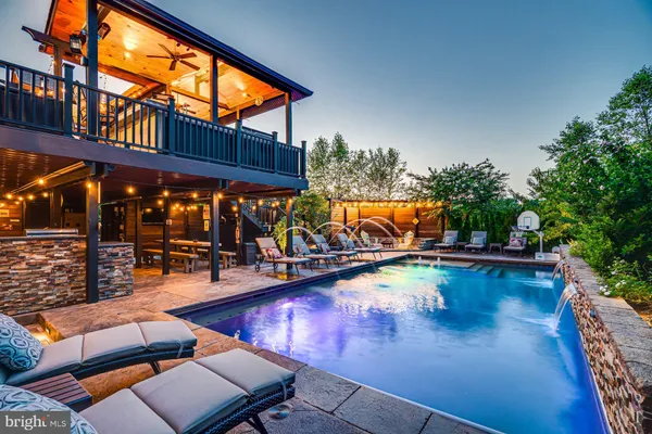 a view of a patio with couches and table and chairs with wooden floor and fence