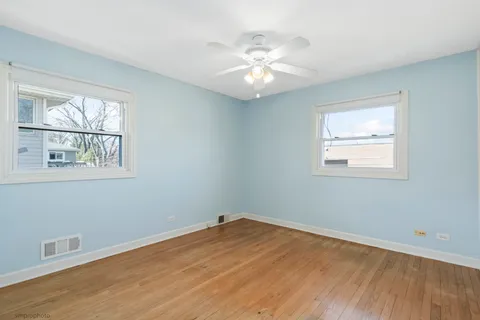 a view of a room with wooden floor and windows