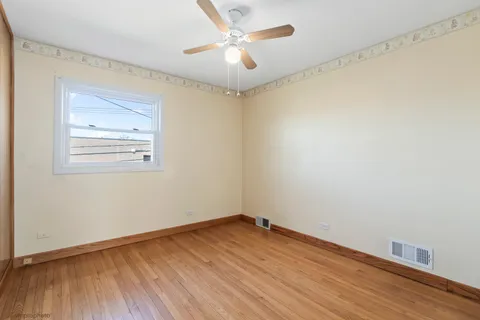 an empty room with a window and a ceiling fan