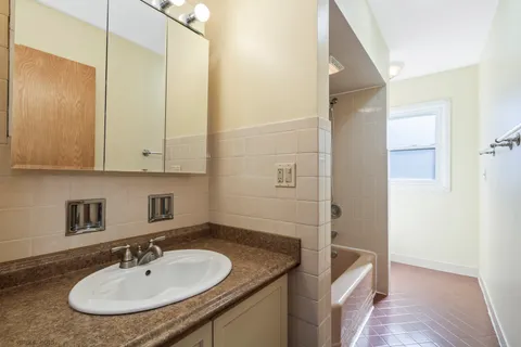 a bathroom with a granite countertop sink a mirror and vanity