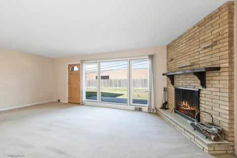 an empty room with floor to ceiling window and an outdoor kitchen