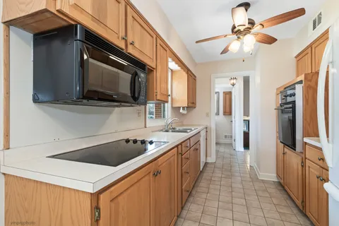 a kitchen with stainless steel appliances kitchen island a sink a stove and cabinets