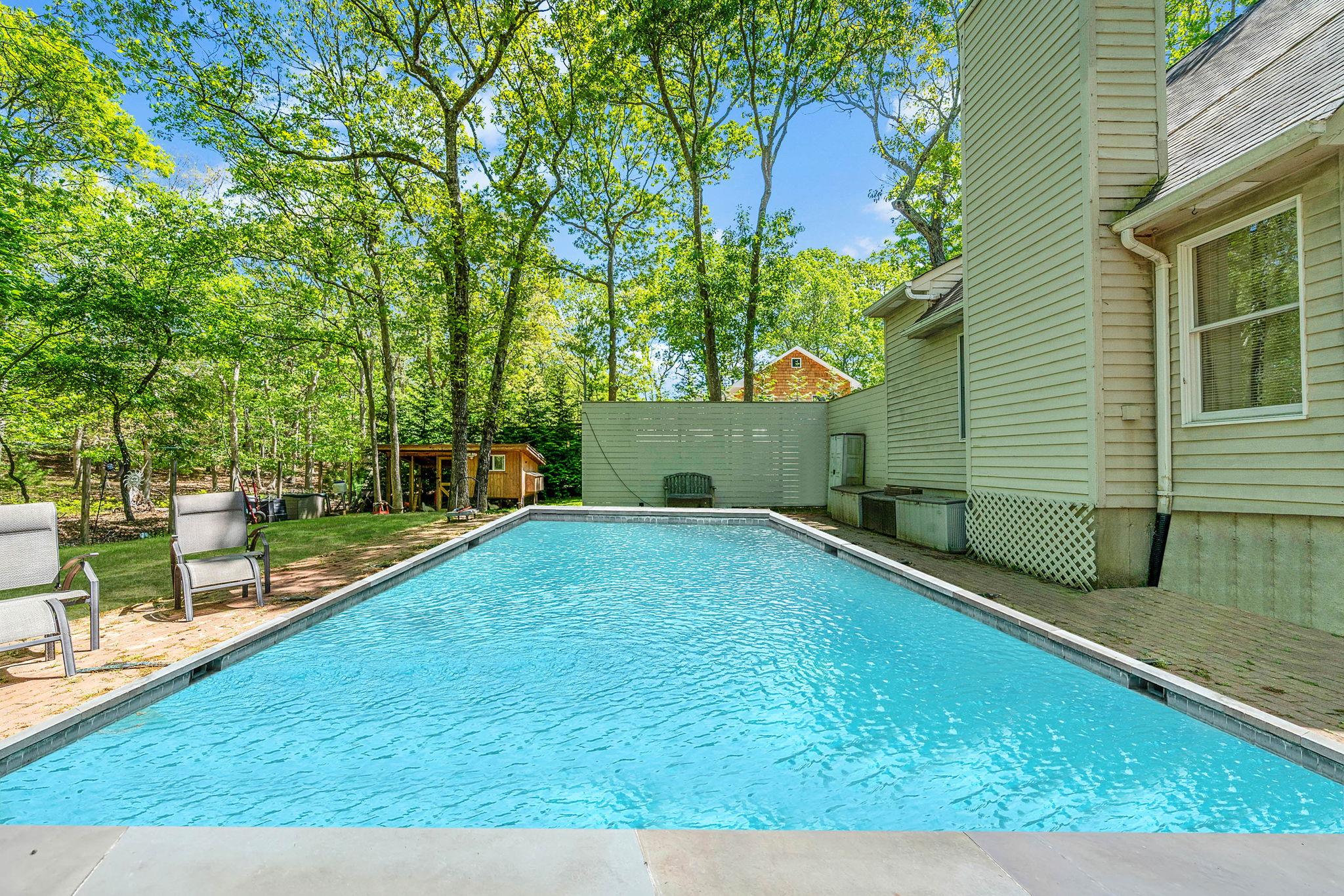28 Huntting Road East Hampton, NY 11937 - Photo 11 of 14 Swimming pool with an outdoor structure and view of scattered trees