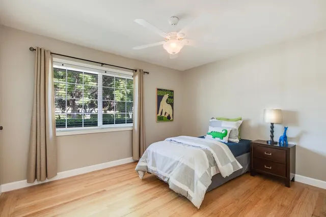 a bedroom with a bed and a large window
