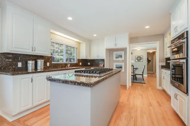 a kitchen with stainless steel appliances granite countertop a stove a sink and a refrigerator