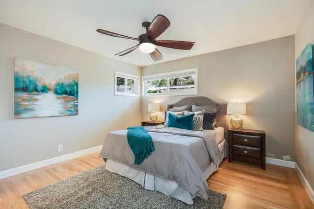 a bedroom with a bed and painting on the wall