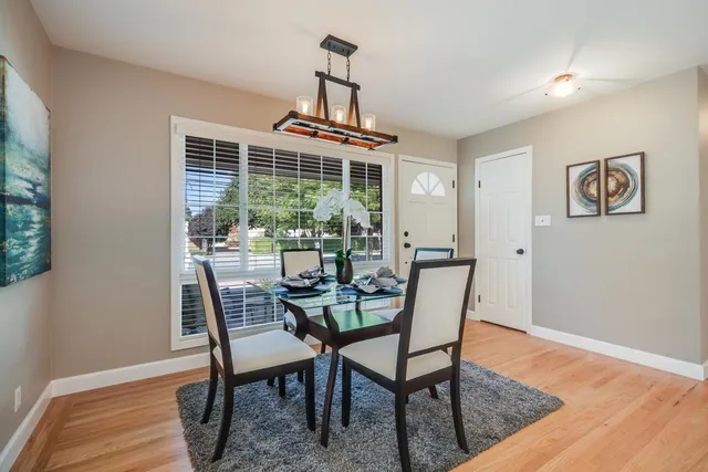 a dining room with furniture window and wooden floor