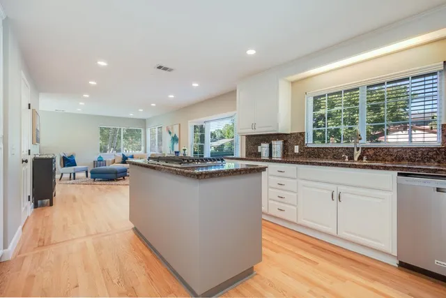 a kitchen with stainless steel appliances granite countertop a sink counter space cabinets and a large window