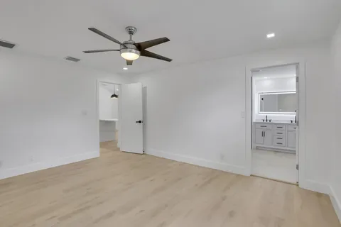 an empty room with closet and a ceiling fan