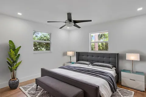 a bedroom with a bed potted plant and a lamp