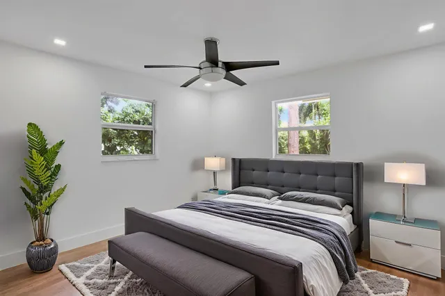 a bedroom with a bed potted plant and a lamp