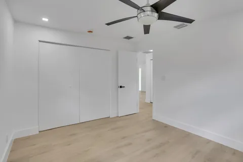 en empty room with ceiling fan and window