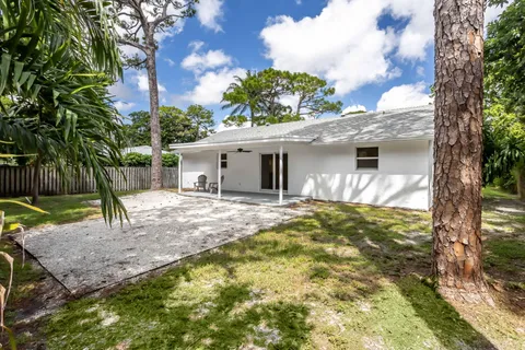 a view of a house with backyard and tree