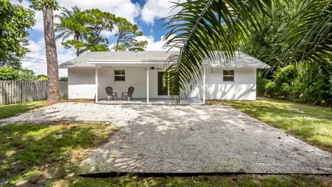 a front view of a house with a yard and potted plants