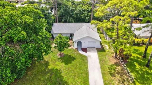 an aerial view of residential houses with outdoor space and trees