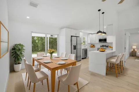 a dining room with furniture potted plants and wooden floor