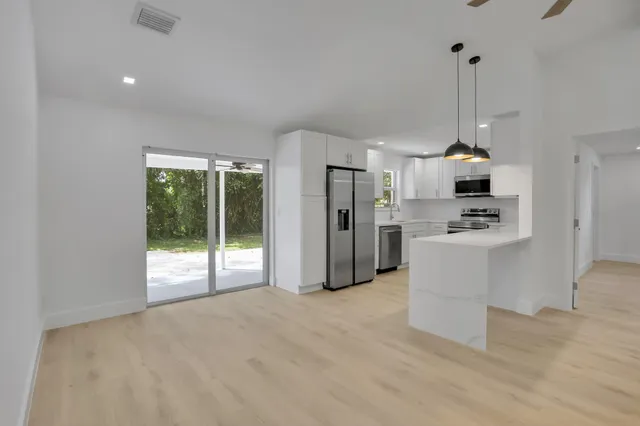 a view of kitchen with stainless steel appliances kitchen island refrigerator stove and oven