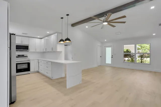 a kitchen with kitchen island a stove a sink and a refrigerator