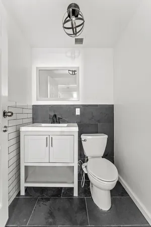 a bathroom with a toilet sink and mirror
