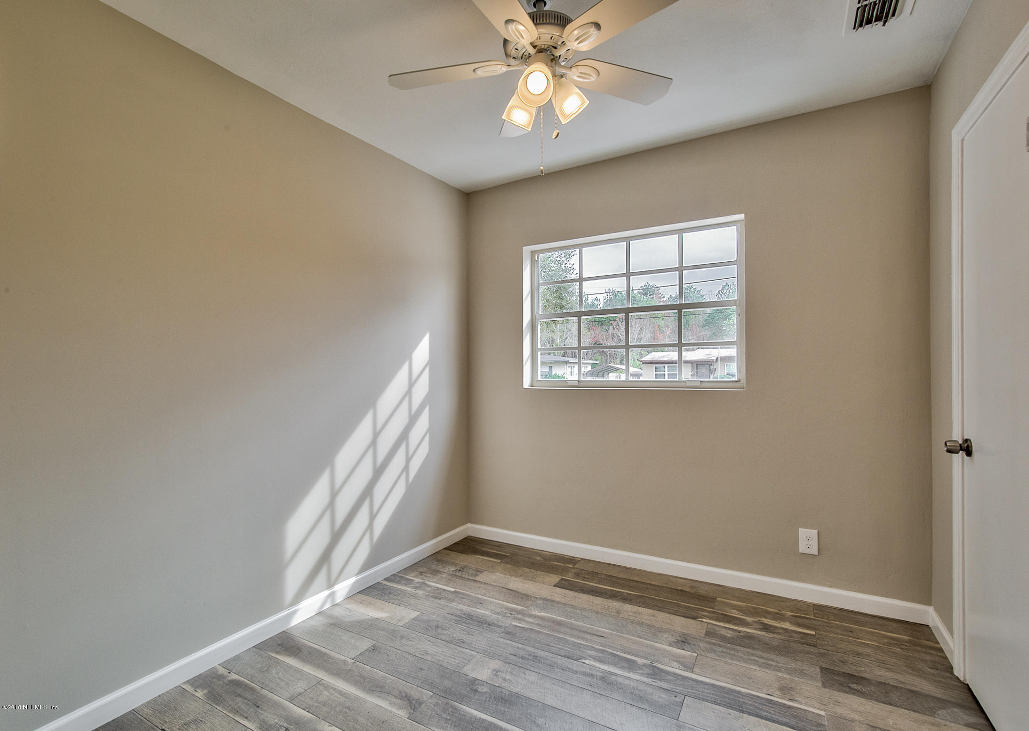 2846 Kline Road Jacksonville, FL 32246 - Photo 30 of 51 a view of an empty room with wooden floor and a window