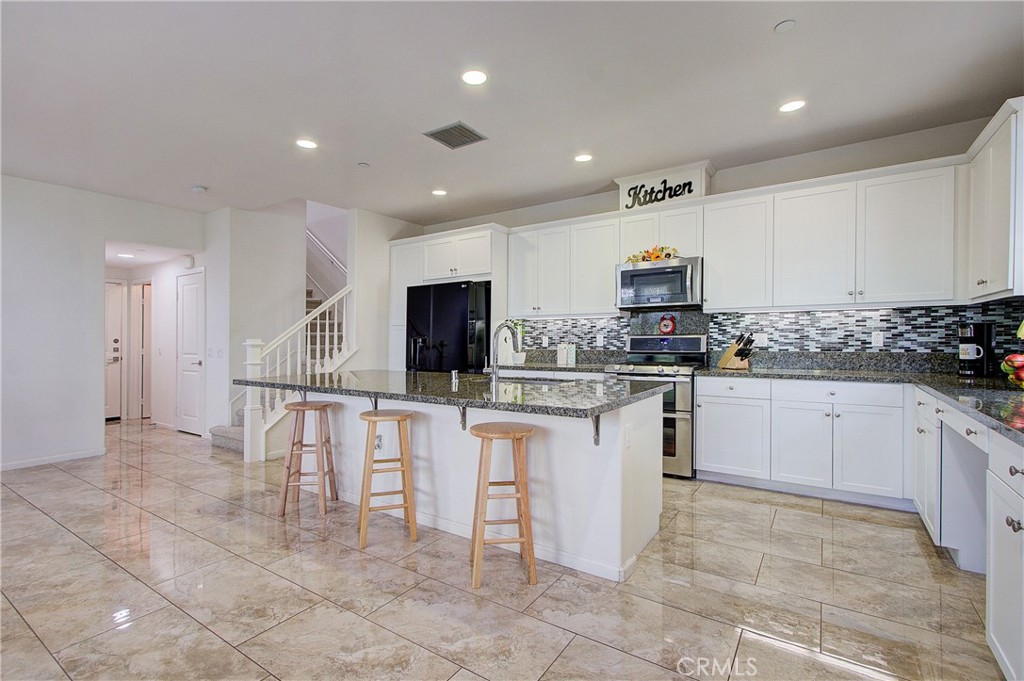 809 El Paseo Lake Forest, CA 92610 - Photo 7 of 45 a kitchen with white cabinets a sink and appliances