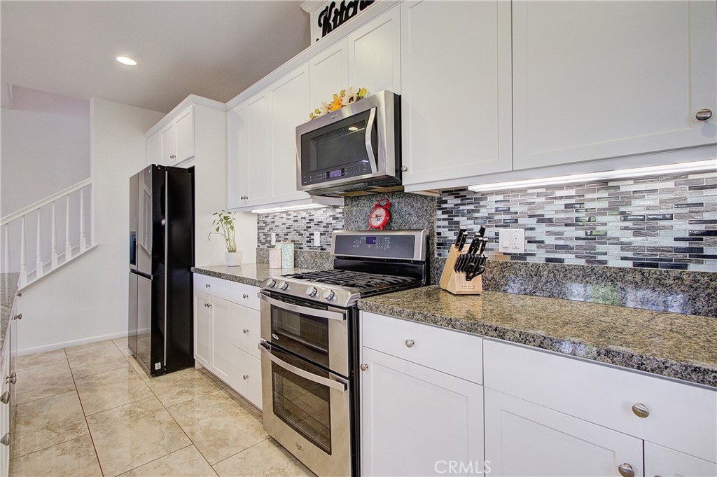 809 El Paseo Lake Forest, CA 92610 - Photo 10 of 45 a kitchen with granite countertop a stove sink and refrigerator