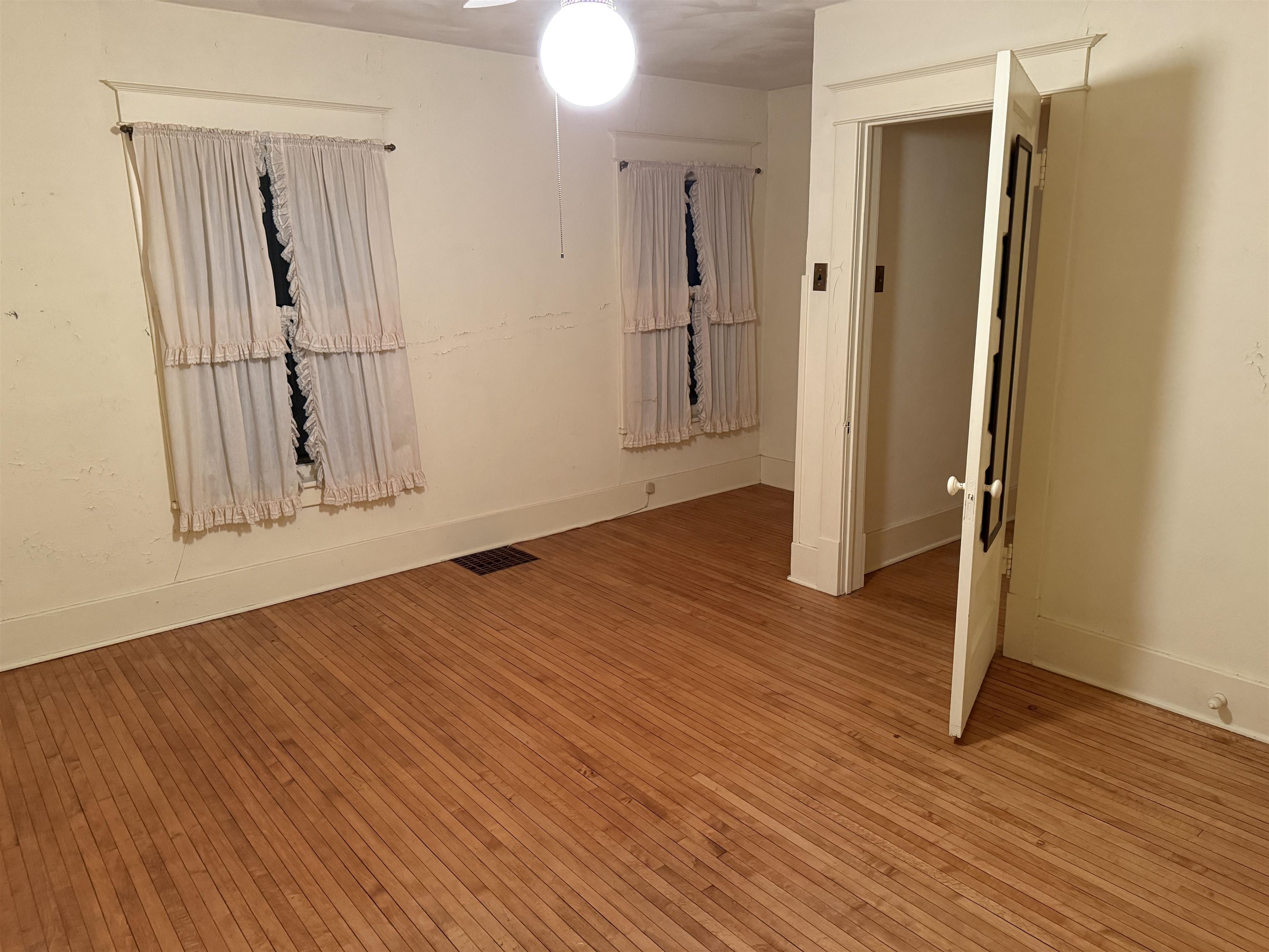 1629 West Harrison Street Freeport, IL 61032 - Photo 20 of 36 an empty room with wooden floor and a mirror