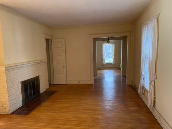 a view of a hallway with wooden floor and a fireplace
