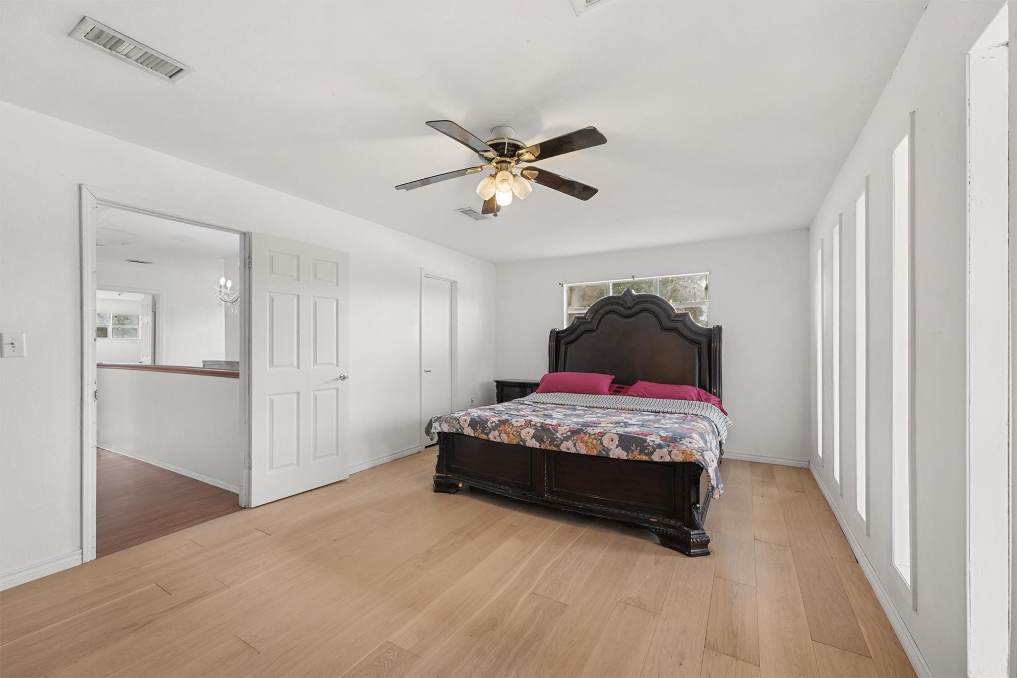 850 County Road 2145 Cleveland, TX 77327 - Photo 24 of 43 a bedroom with a bed and a chandelier