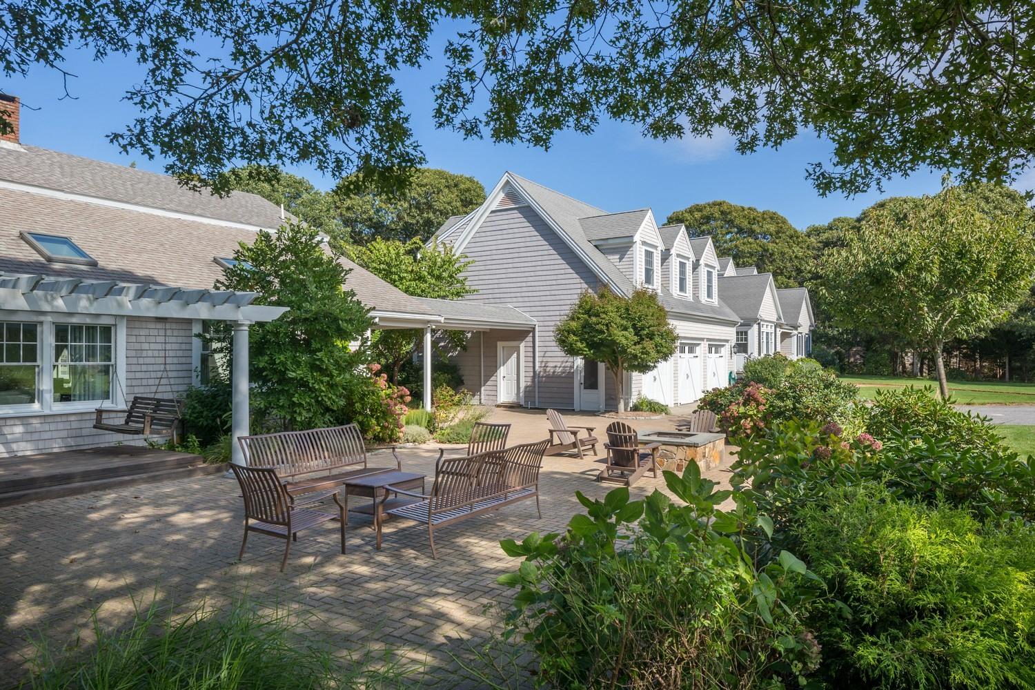 721 Samoset Road Eastham, MA 02642 - Photo 19 of 32 a view of a patio with table and chairs potted plants and large tree